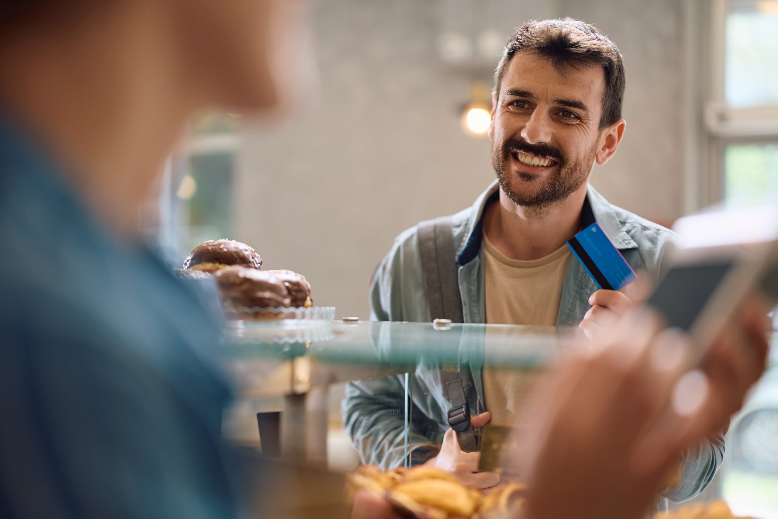 Happy customer enjoying coffee at a local shop—illustrating the power of customer retention through personalized experiences.