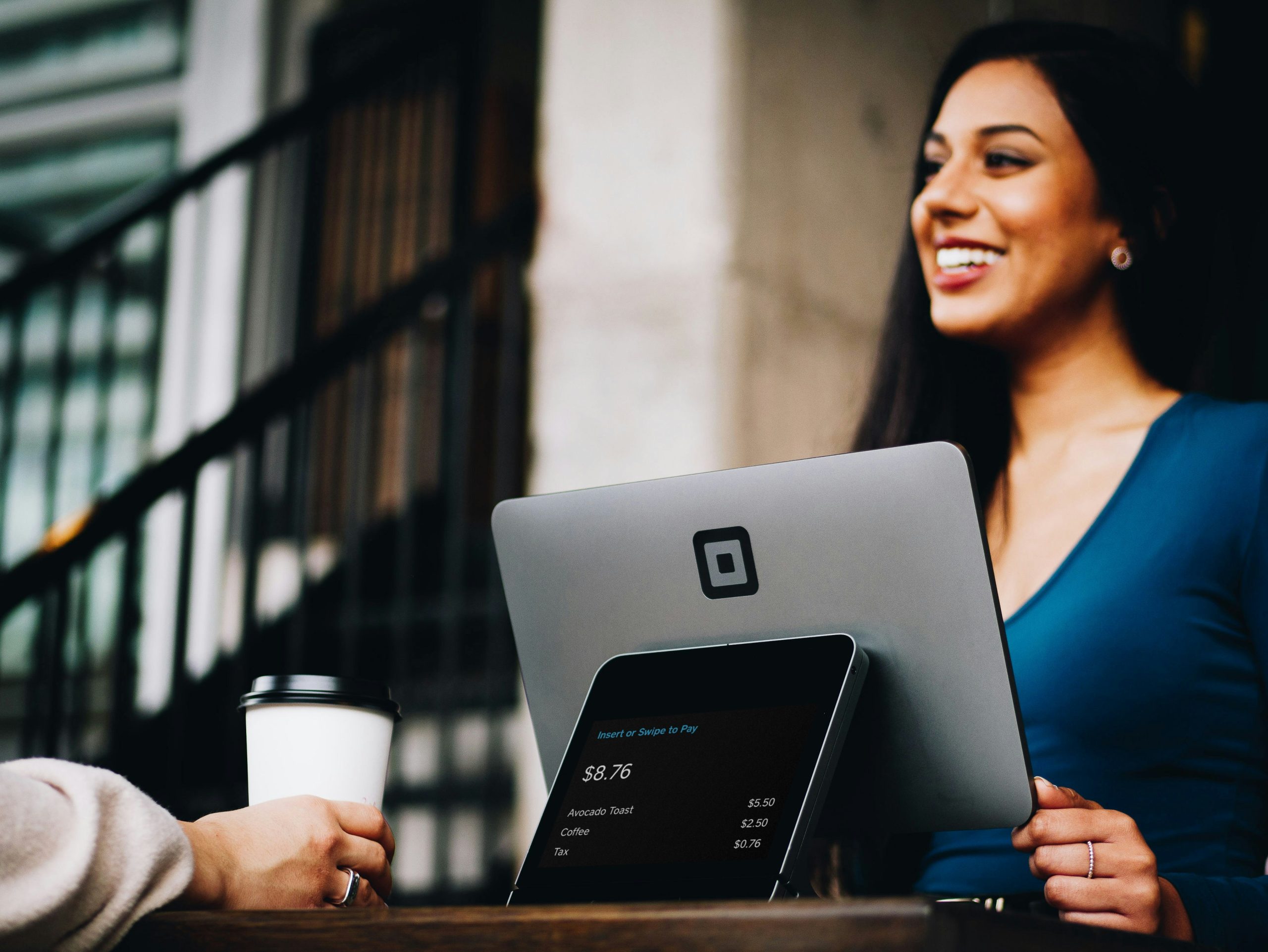 Woman working on a laptop in a modern business setting, analyzing customer feedback and tracking Net Promoter Score data.